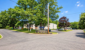 A street view of a roundabout with a signboard in the middle.