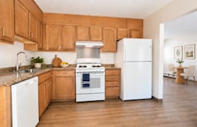 A kitchen with wooden cabinets and a white refrigerator.