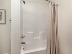 a white bath tub sitting next to a shower curtain