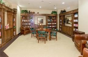 A room filled with bookshelves and a table in the middle.