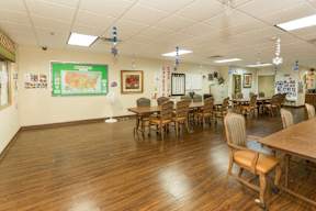 A classroom with wooden floors and tables.