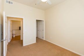 A room with a carpeted floor and two doors.