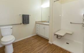 A bathroom with a toilet, sink, and shower.