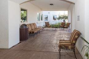 A patio with a striped couch and chairs.