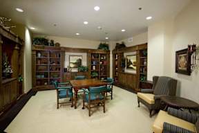 A living room with a wooden table surrounded by chairs.
