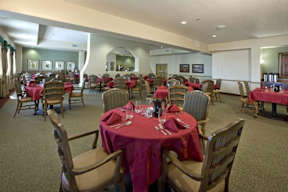A dining room with tables set for a meal.