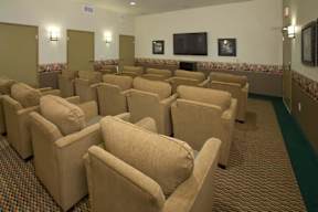 A room with rows of chairs facing a television.