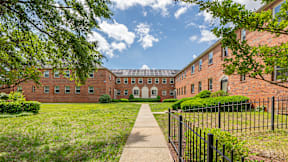 A long brick building with a walkway in front at Eagles Crossing Apartments, Washington DC, 20032