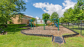 A playground with a green swing set and a slide at Eagles Crossing Apartments, Washington, DC, 20032
