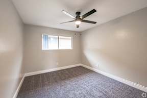 A room with a ceiling fan and a window.
