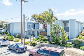 A car is parked on the street in front of a house.