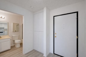 A bathroom with a toilet, sink, and a door.