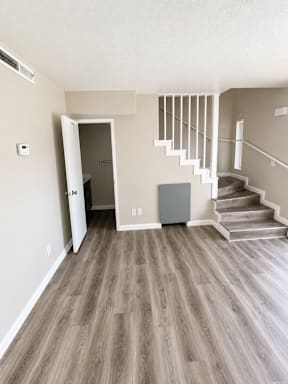 A room with a staircase and a refrigerator.