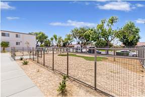 A fenced area with a building in the background.