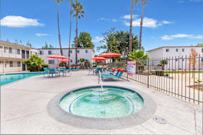 A pool with a fountain in the middle of it.