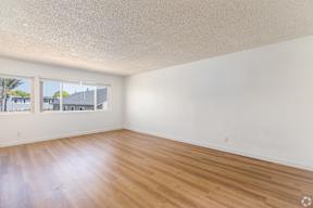 Empty room with wooden floor and white walls.