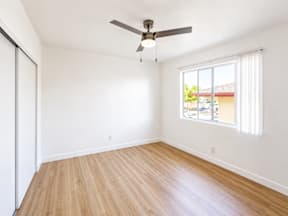 A room with a ceiling fan and a window.