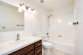 A white bathroom with a sink, toilet, and bathtub.