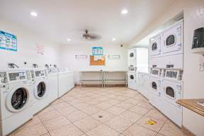 A laundromat with a row of washers and dryers.