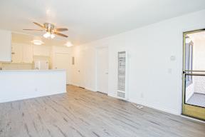 A room with a ceiling fan and wooden flooring.