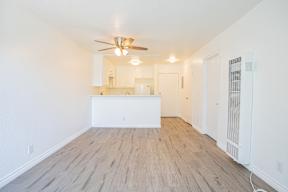 A room with a ceiling fan and wooden flooring.
