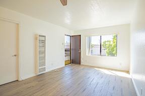 A room with a wooden floor and a ceiling fan.