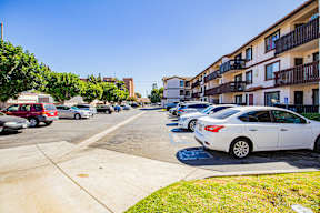 A white car is parked on the right side of a street.