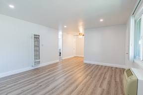 A room with wooden flooring and white walls.
