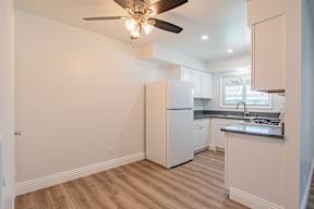 A kitchen with a refrigerator, stove, and sink.