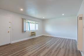 A room with a window and a radiator on the floor.