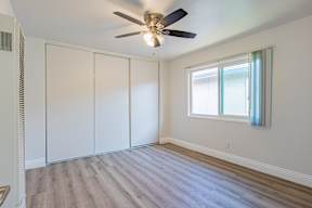 A room with a ceiling fan and a window.