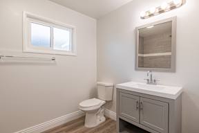 A white toilet sits next to a sink in a small bathroom.