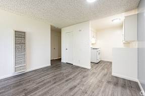 A room with a white fridge and a white cabinet.