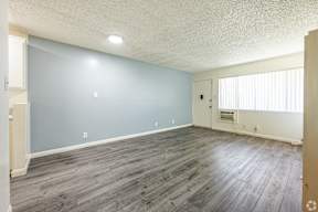 A room with a light blue wall and wooden flooring.