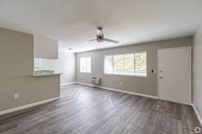 A room with a ceiling fan and a window with blinds.