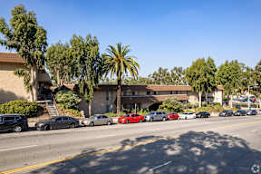 Cars parked on the side of a road in front of a building.
