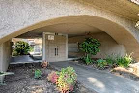 A concrete archway with a door and a sign that says "No Parking" on it.