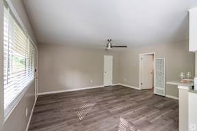 A room with a ceiling fan and a window with blinds.