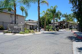a street with houses on each side and a sign that reads oak 51 terrace at Oak Terrace Senior Apts, Hemet California
