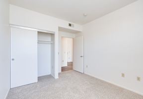 a bedroom with white walls and carpet at Helix at University Village, Pomona California