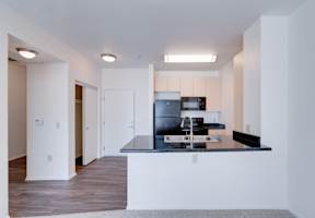 a kitchen with a black counter top and a sink at Helix at University Village, Pomona
