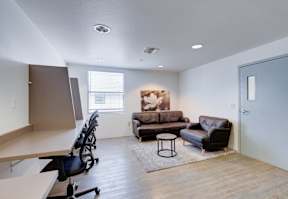 our apartments offer a living room with a couch and a coffee table at Helix at University Village, Pomona
