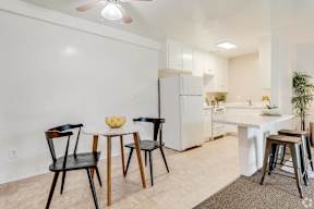 a dining area with a table and chairs and a kitchen with a refrigerator at University Park, California
