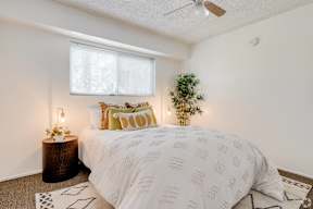a bedroom with a bed and a plant and a ceiling fan at University Park, Azusa