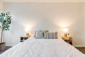 a bedroom with a large white bed and white walls at University Park, Azusa