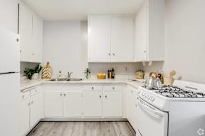 a white kitchen with white appliances and white cabinets at University Park, Azusa, CA