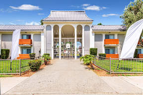 a white building with a walkway and a gate at Sunnymead Apts Apartments, California