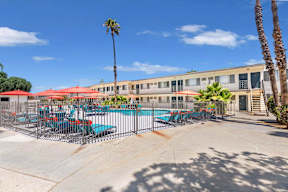 our apartments have a pool and patio with chairs and umbrellas at Sunnymead Apts Apartments, Moreno Valley, CA