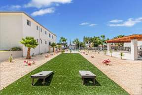 a garden outside a building with grass and benches at Sunnymead Apts Apartments, Moreno Valley, CA