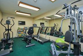 a gym with weights and other exercise equipment in a home gym at Huntington Terrace North Senior, Huntington Beach, CA 92648
